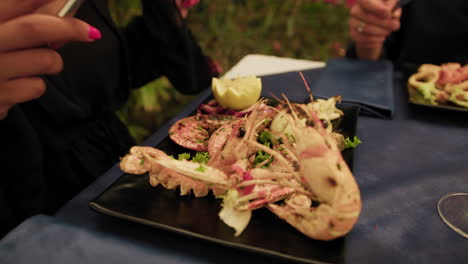 woman picking fork to start eating lobster gourmet dish