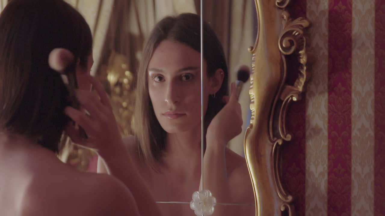 Young female applying makeup in evening