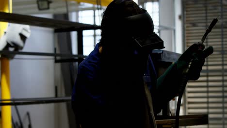 female welder holding blowing torch 4k