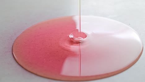 thin stream of pink fluid poured on white tile