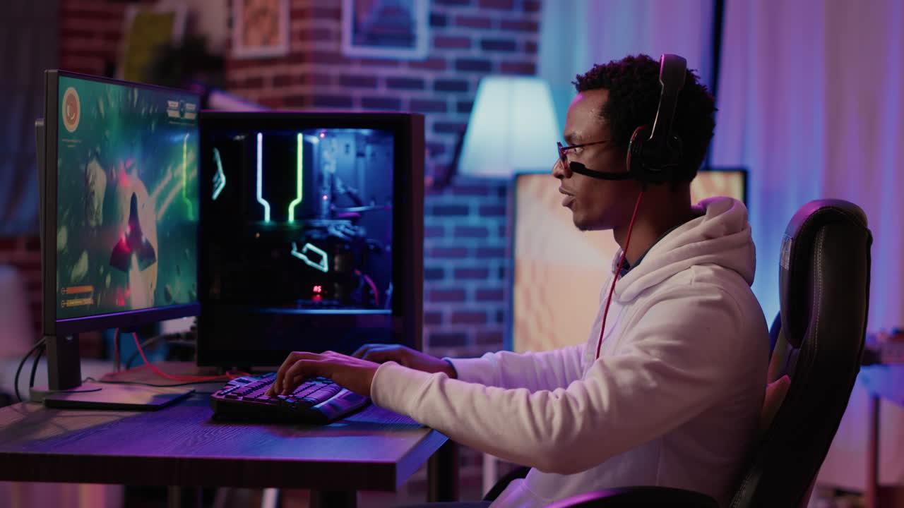 Gamer playing fast paced multiplayer space shooter competition using pc gaming setup having relaxing time