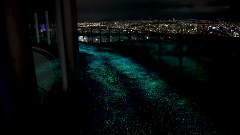 illuminated led path on top of building overlooking osaka city skyline at night