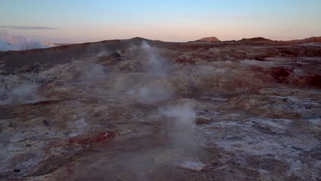 steam coming out in mud pots in gunnuhver geothermal area in iceland - medium shot