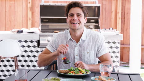 Young-white-man-sitting-at-a-table-in-the-garden