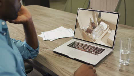 Hombre-Afroamericano-En-La-Mesa-Usando-Laptop,-Compras-En-Línea-De-Productos-De-Belleza,-Cámara-Lenta