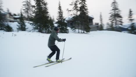 4k tracking of skier going downhill fast on the ski slope on telemark skis on a cold cloudy day in ski resort in norway