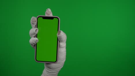 detail green screen isolated chroma key video capturing mummy's hand holding a smartphone and