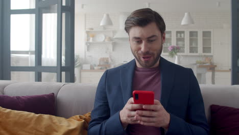 Surprised-businessman-reading-news-on-phone-at-home-office.-Guy-feelling-happy