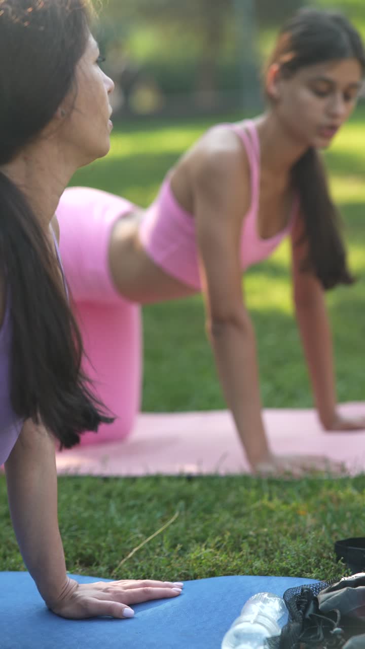 dos mujeres practicando yoga al aire libre