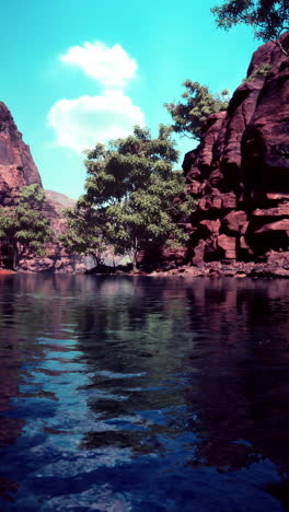 un hermoso lago de cañón con rocas rojas y cielo azul