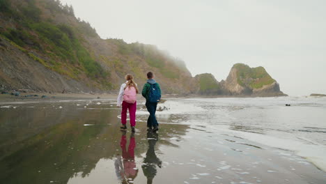 couple walking on a misty pacific coast beach
