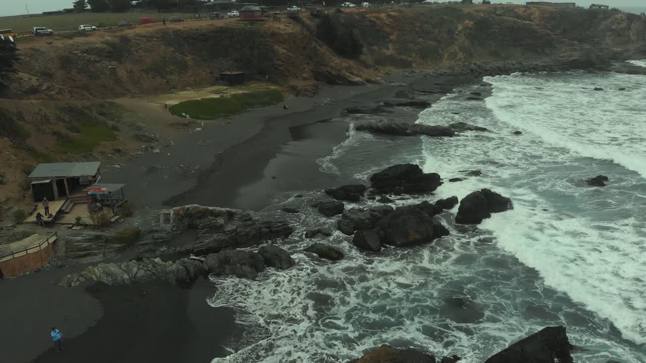 toma aérea volando a lo largo de la playa en un día clody en pichilemu, chile-4k