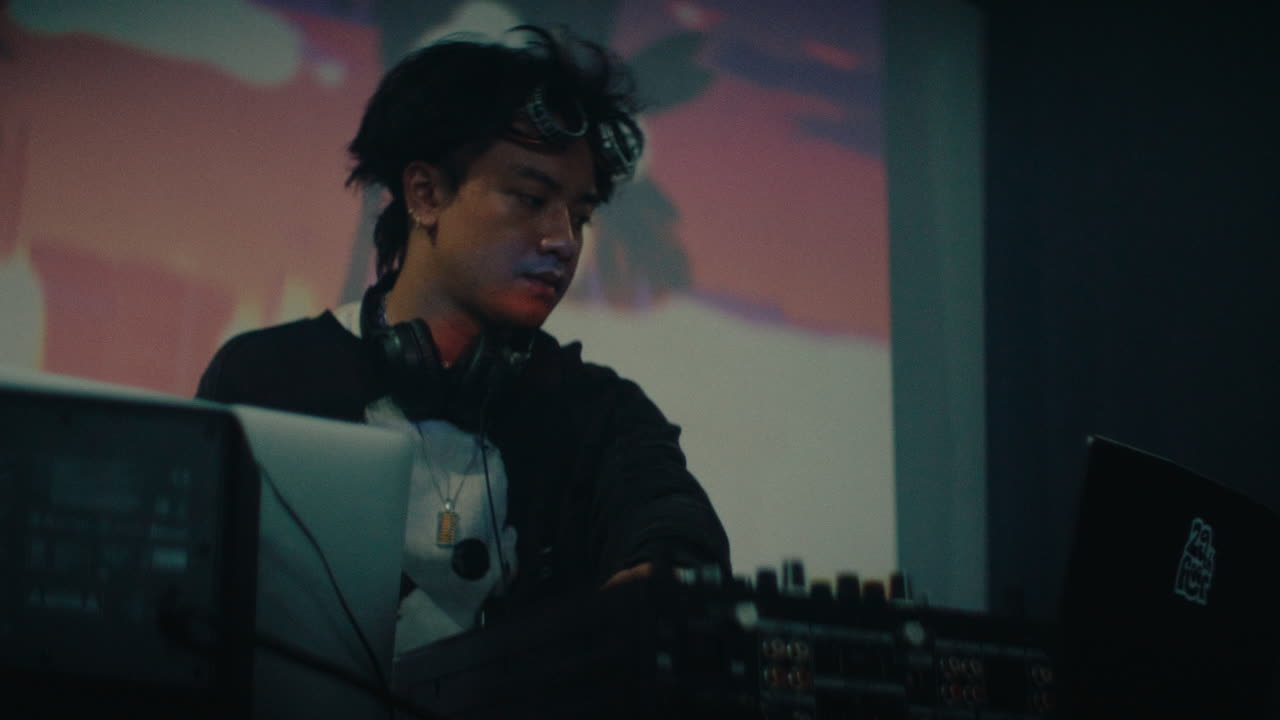 young alternative dj playing music on stage of music fest event party