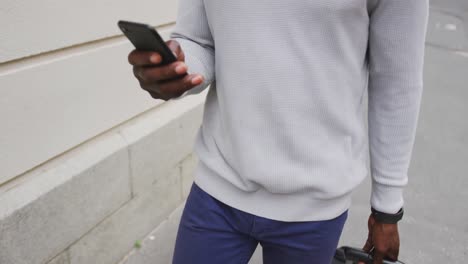 Afroamerikanischer-Mann,-Der-Auf-Der-Straße-Läuft-Und-Sein-Telefon-Benutzt