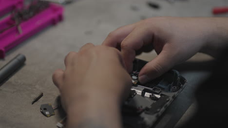 human hands assembling electronic joystick components on a workbench for a repairing.