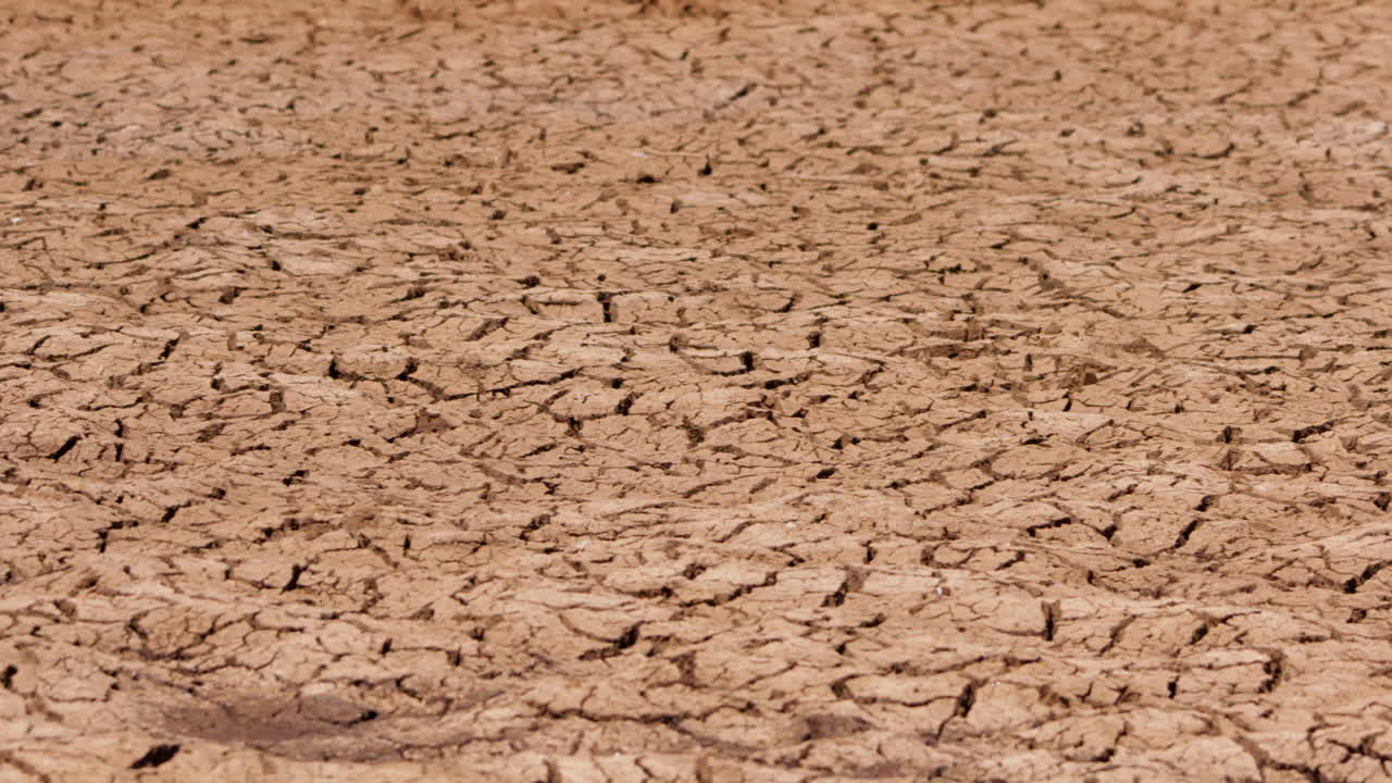 Wide pan shot of cracked earth during a hot afternoon in Kenya