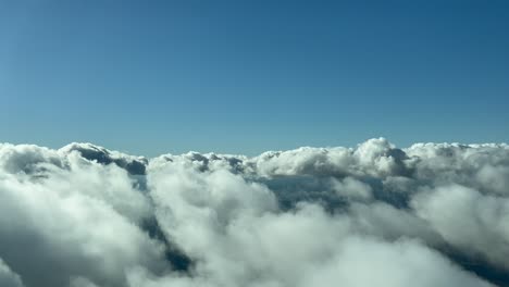 flying across a clouded sky with some fluffy clouds, as seen by the pilots