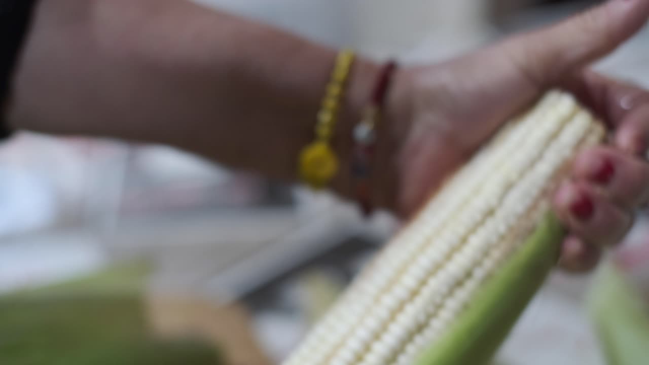 cortar y pelar las manos de una mazorca de maíz fresca, mazorca de maíz, cerrar