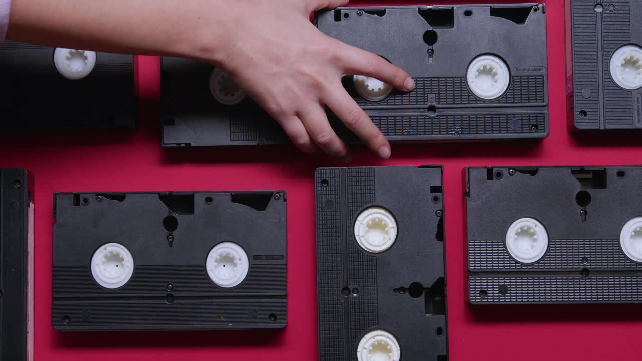 VHS cassettes on burgundy background