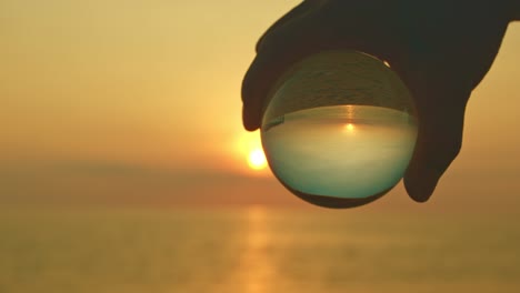 magic sunset view in a crystal ball on your hand.