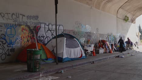 personas sin hogar que viven bajo un paso elevado en los ángeles, california