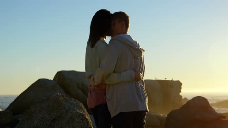 Romantic-couple-kissing-each-other-on-the-rocky-shore-4k