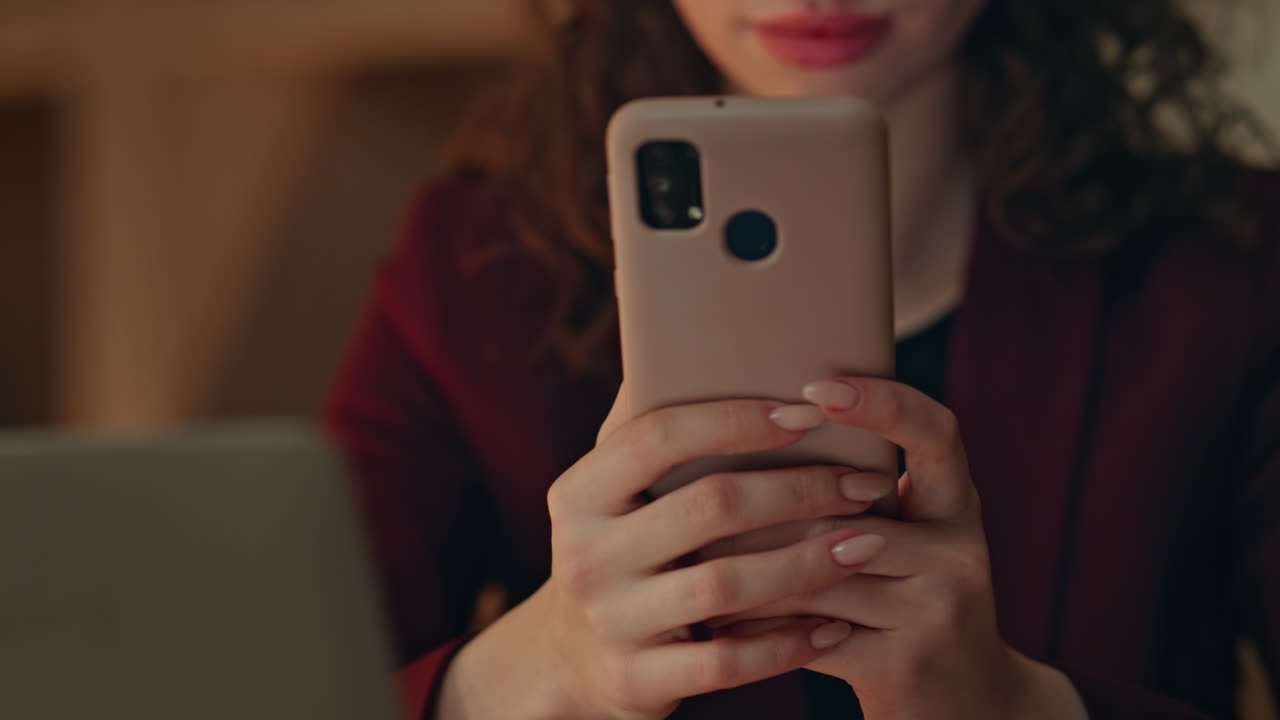 Girl employee texting cellphone at dark workplace closeup. Unknown businesswoman
