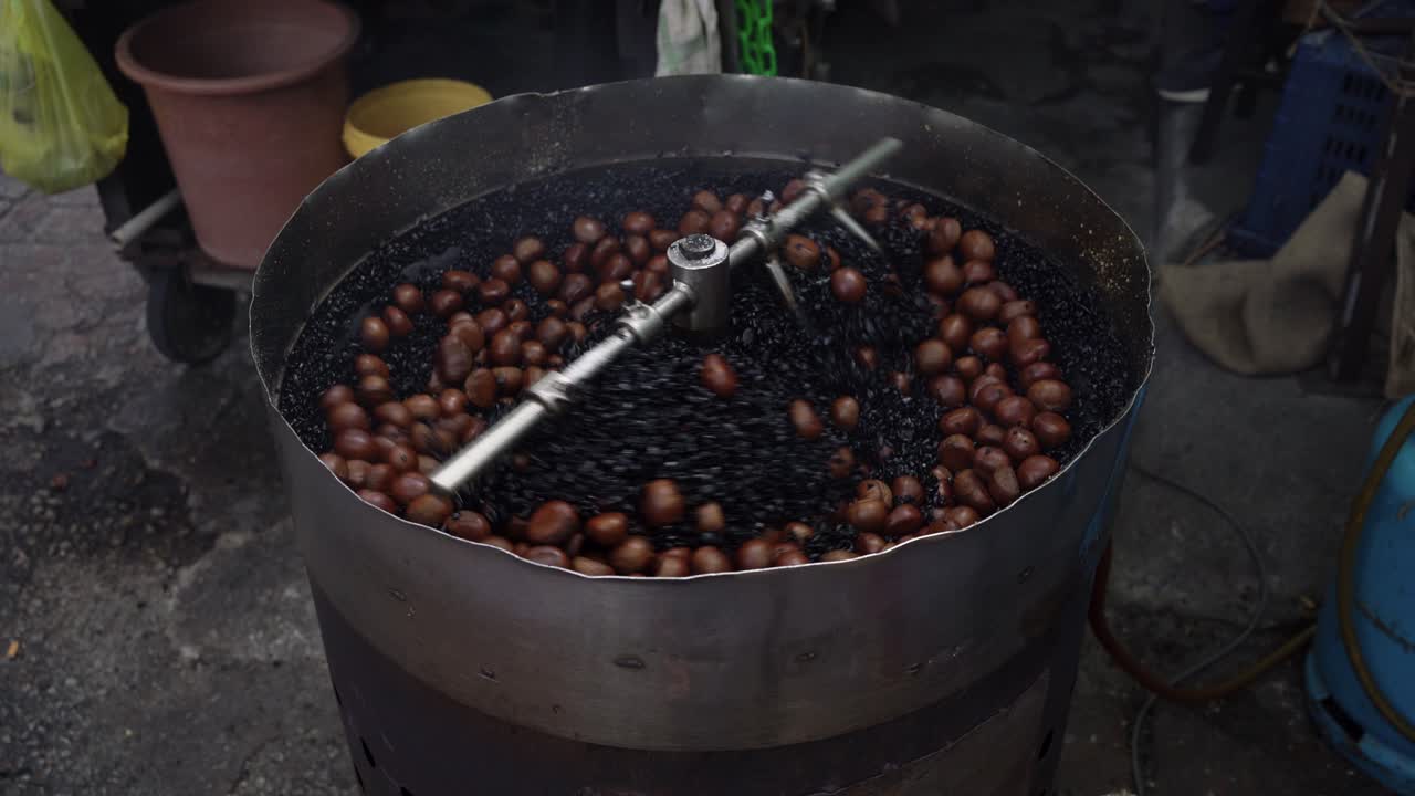 Circular movement of a auto roasting machine roasting chestnuts, famous street food