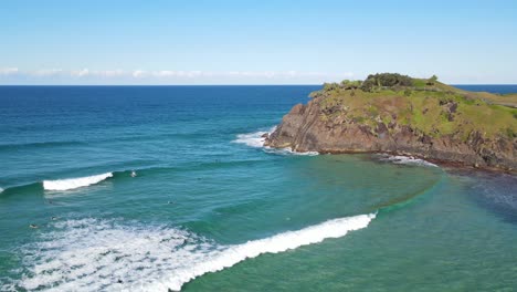 tourists floating with their surf boards at the wavy beach of norries cove in nsw, australia