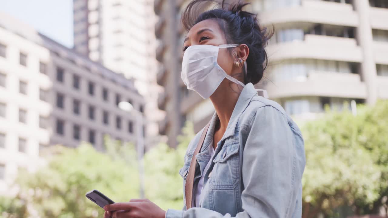 Mixed race woman wearing medical coronavirus mask on the street
