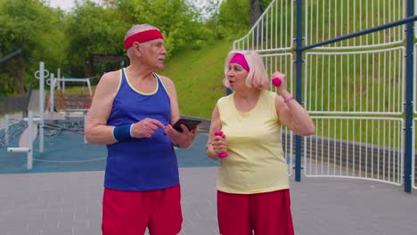 entrenador de abuelo sénior enseñando a la abuela con deportes levantamiento de pesas ejercicios de cardio
