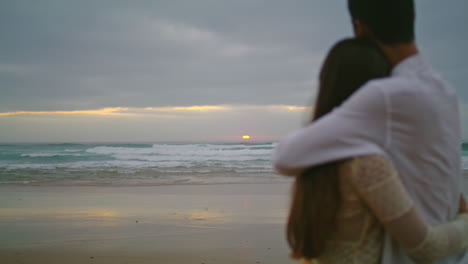 lovers silhouettes dating ocean beach evening. unknown romantic couple embracing