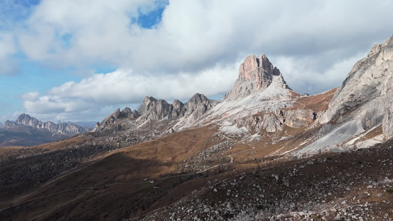 A breathtaking aerial view of the rugged Dolomite mountains in Passo Giau under a bright cloudy sky
