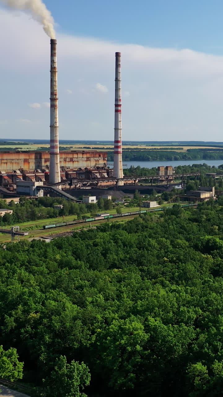 Industrial place from above. Flying above factory surrounded by green trees