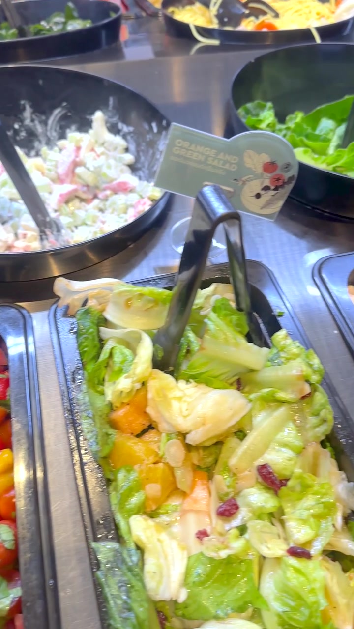 Una ripresa dall'alto panoramica su un vivace salad bar di un ristorante con vari piatti di verdure fresche