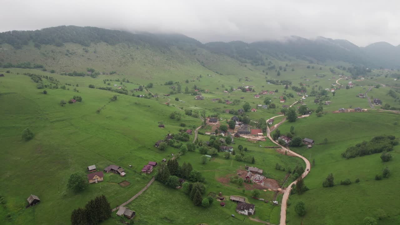 un paisaje verde exuberante de un pueblo pintoresco con un cielo nublado, vista aérea