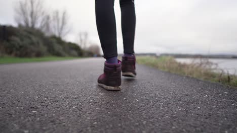 cámara lenta, baja, primer plano desde la parte posterior de una niña caminando con muy poca profundidad de campo