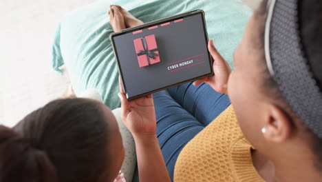 african american mother and daughter using tablet, shopping online on cyber monday, slow motion