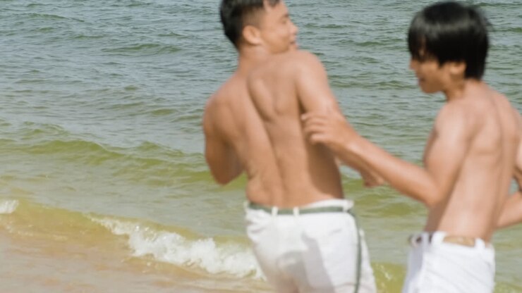 Two men dancing capoeira on the beach