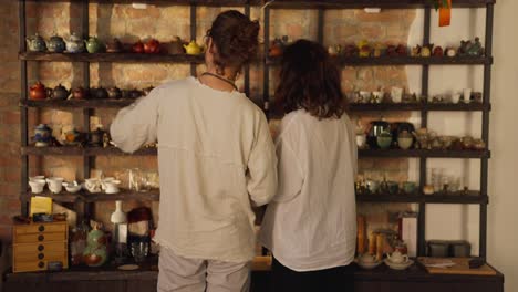 couple browsing teapots in a cozy tea shop