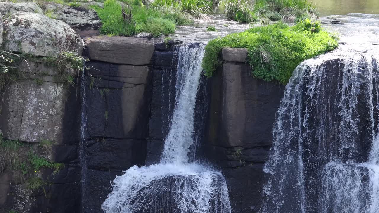 푸른 숲 이 있는 바위 절벽 위 에 있는 폭포