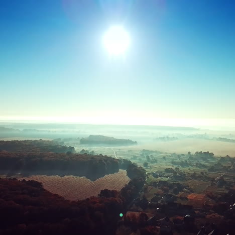 morning sunrise in the village on misty weather. panoramic view of beautiful dawn over the roofs of the houses and big forest. aerial view. soft sun light. slow motion.