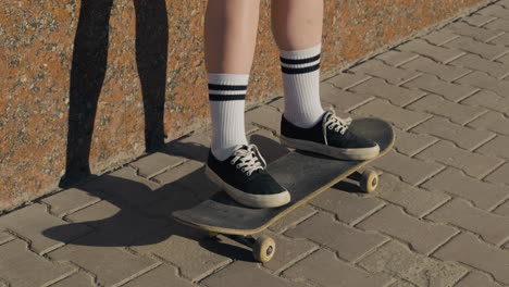 the feet of an unrecognisable skater girl on a skateboard