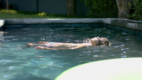 teenage asian boy enjoys a relaxing swim in a sunlit pool