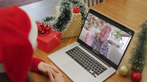 Caucasian-woman-on-video-call-with-grandfather-at-christmas-time