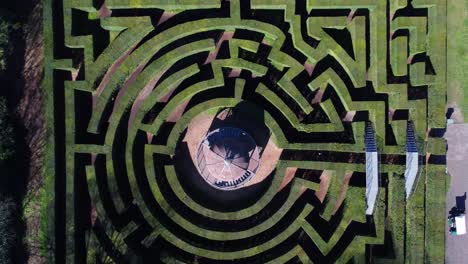 bird's eye view of a green beautiful hedge labyrinth with pavilion