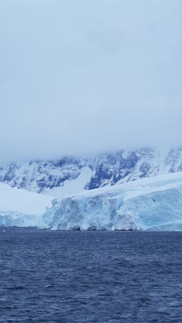 Glaciar-Antártico-Y-Mar-En-La-Costa-Con-Montañas,-Hermoso-Y-Dramático-Paisaje-De-La-Península-Antártica-Con-Nieve-Y-Hielo,-Video-Vertical-Para-Redes-Sociales,-Carretes-De-Instagram-Y-Tiktok