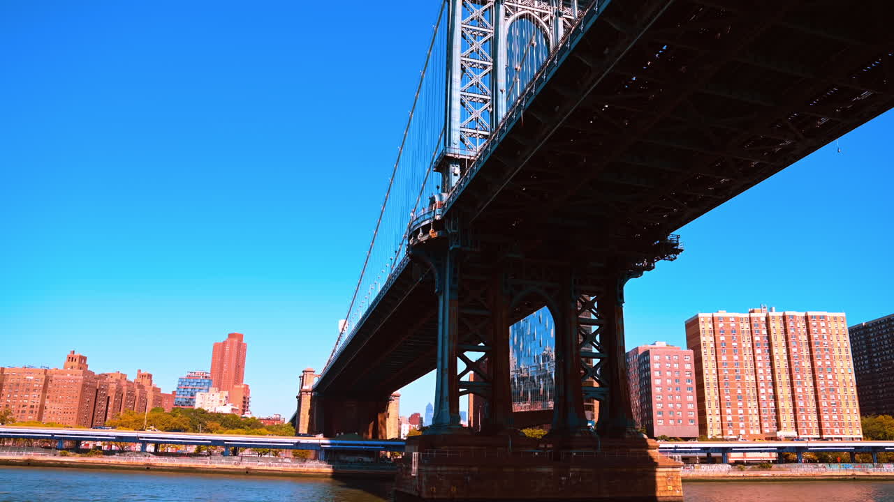 Prospettiva sotto il Manhattan Bridge. Vista dal basso del Manhattan Bridge che mette in risalto la struttura in acciaio e gli edifici sul lungomare
