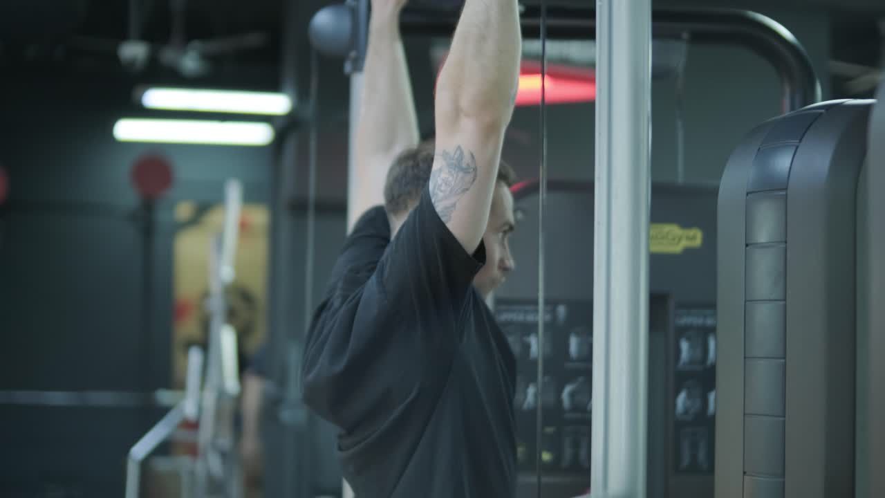 hombre realizando pull-ups en un gimnasio