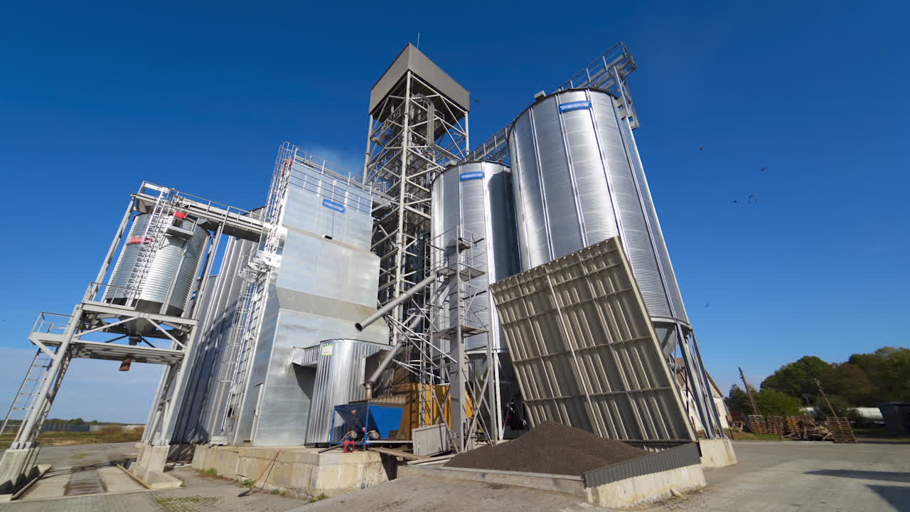 Panoramic view of a modern warehouse. New industrial factory on blue sky background in the countryside. Metal storage granary for agribusiness at sunlight.